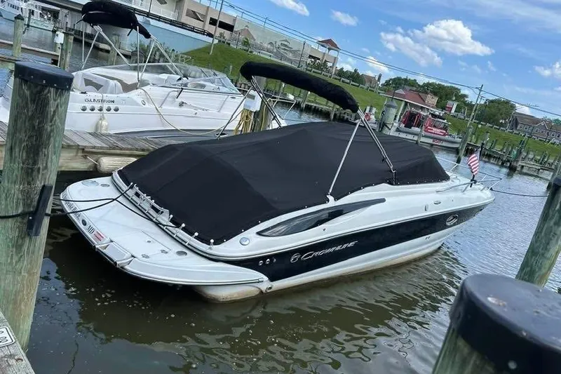 Slide: The Image of 2011 Crownline 286 SC boat docked with black cover, sunny day, marina background. - 9