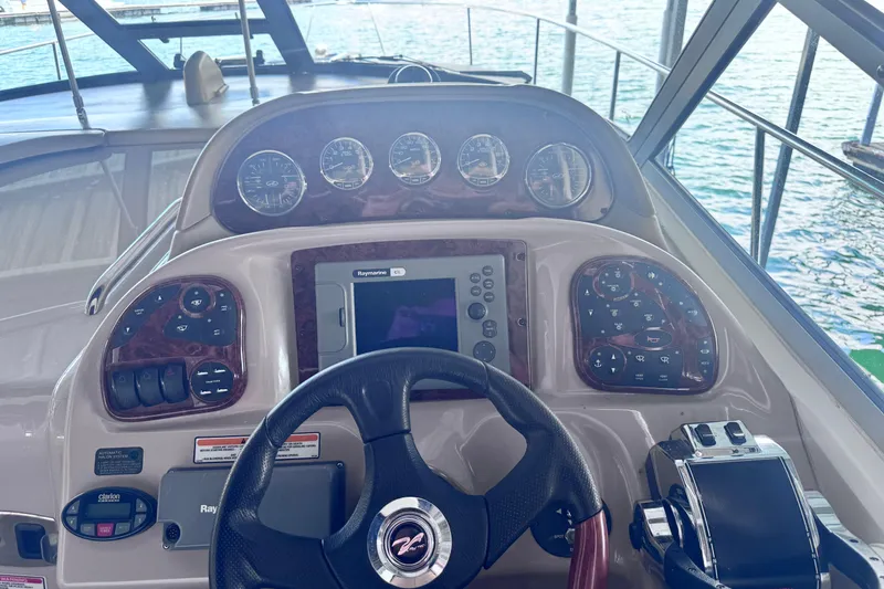 Slide: The Image of Control panel of a 2005 Sea Ray 300 Sundancer boat with steering wheel and gauges. - 12