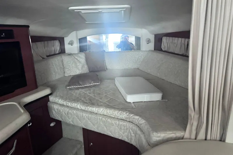 Slide: The Image of Interior cabin of 2005 Sea Ray 300 Sundancer with cushioned seating and curtains. - 13