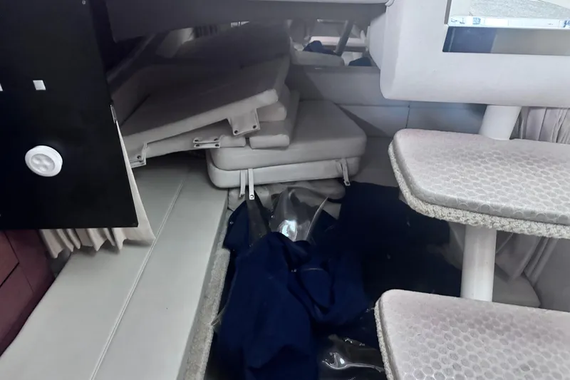 Slide: The Image of Interior cabin of 2005 Sea Ray 300 Sundancer with stacked cushions and carpeted steps. - 16