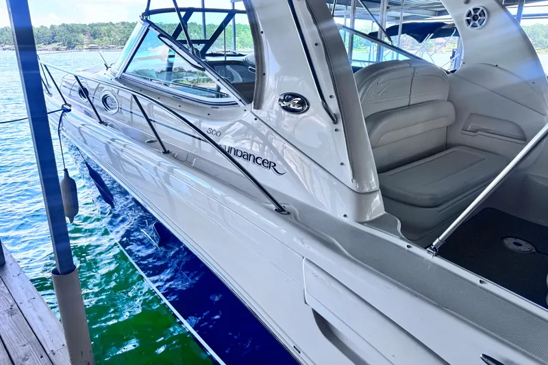 Slide: The Image of 2005 Sea Ray 300 Sundancer boat docked, featuring sleek design and comfortable seating. - 2