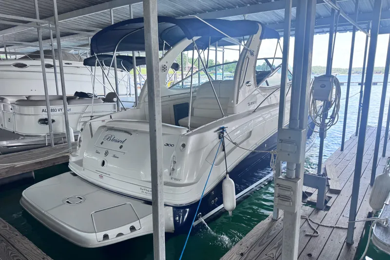 Slide: The Image of 2005 Sea Ray 300 Sundancer docked in a marina, covered by a canopy. - 24