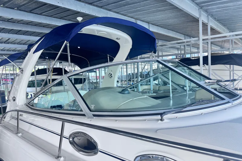 Slide: The Image of 2005 Sea Ray 300 Sundancer boat with blue canopy in marina storage. - 27