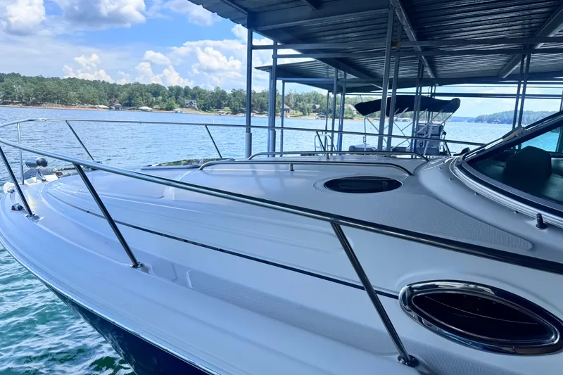 Slide: The Image of 2005 Sea Ray 300 Sundancer docked on a serene lake under a covered slip. - 5