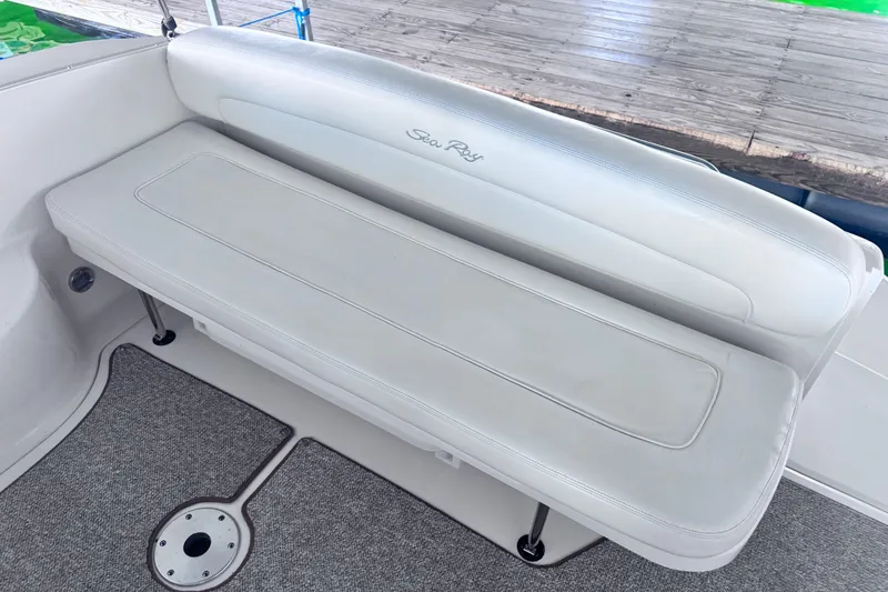 Slide: The Image of 2005 Sea Ray 300 Sundancer boat seating with white upholstery and carpeted floor. - 8