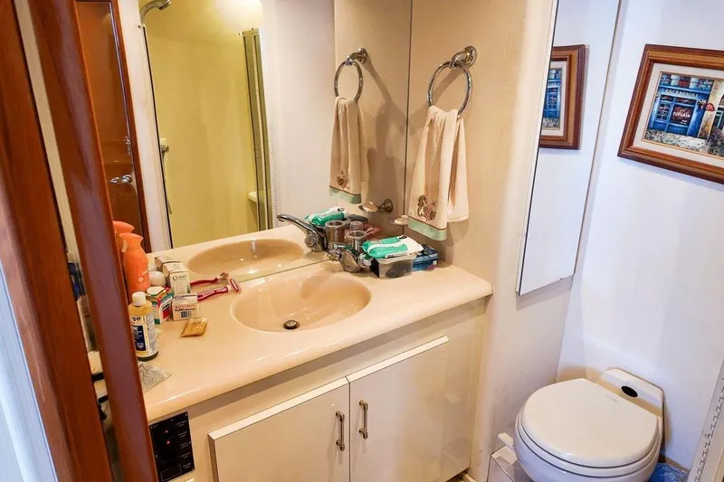 Slide: The Image of 1999 Viking Cockpit Sports Yacht bedroom with cozy bed, wooden cabinets, and decorative lamps. - 10