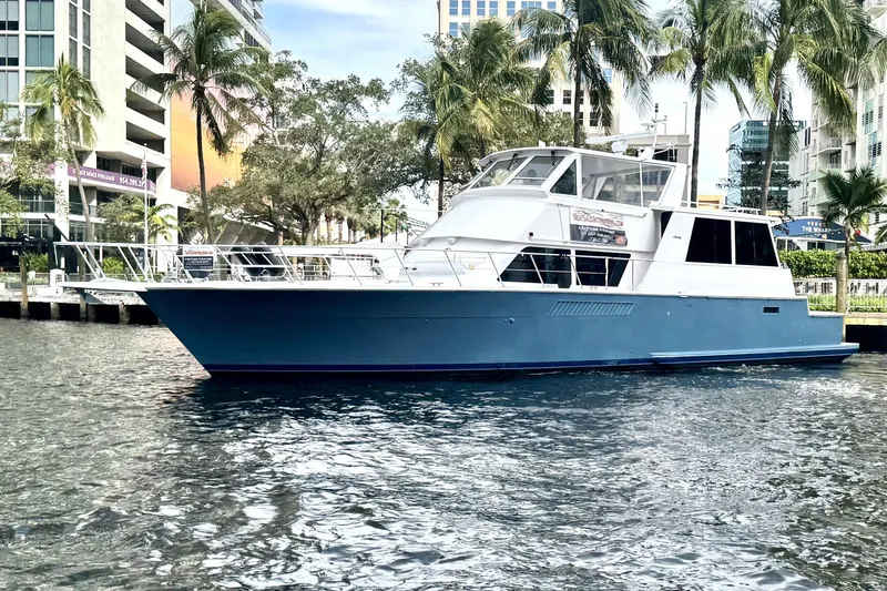 Slide: The Image of 1999 Viking Cockpit Sports Yacht docked near palm trees and modern buildings. - 60