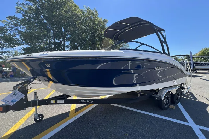 The Image of 2026 Sea Ray SPX 210 boat on trailer, parked outdoors under clear sky. - 0