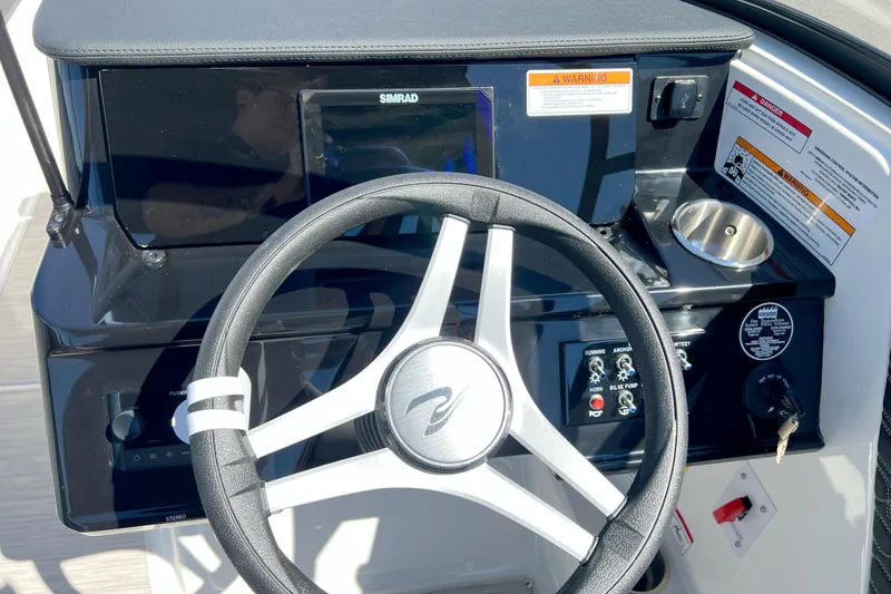 Slide: The Image of Steering wheel and dashboard of 2026 Sea Ray SPX 210 boat with controls and display. - 2