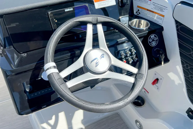 Slide: The Image of Steering wheel of 2026 Sea Ray SPX 210 boat with control panel and cup holder. - 4