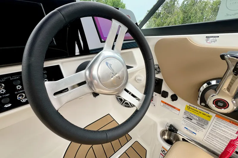 Slide: The Image of Steering wheel and controls of 2026 Sea Ray SDX 230 boat interior. - 12