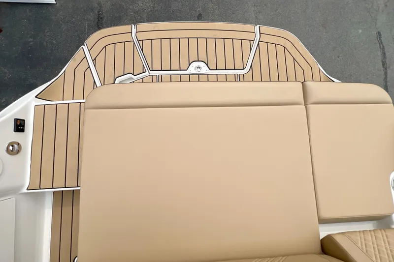 Slide: The Image of 2026 Sea Ray SDX 230 boat deck with tan seating and wood-patterned flooring. - 16