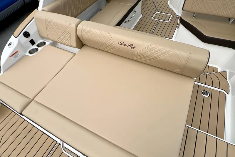 Slide: The Image of 2026 Sea Ray SDX 230 boat interior with beige seating and wood-style flooring. - 7