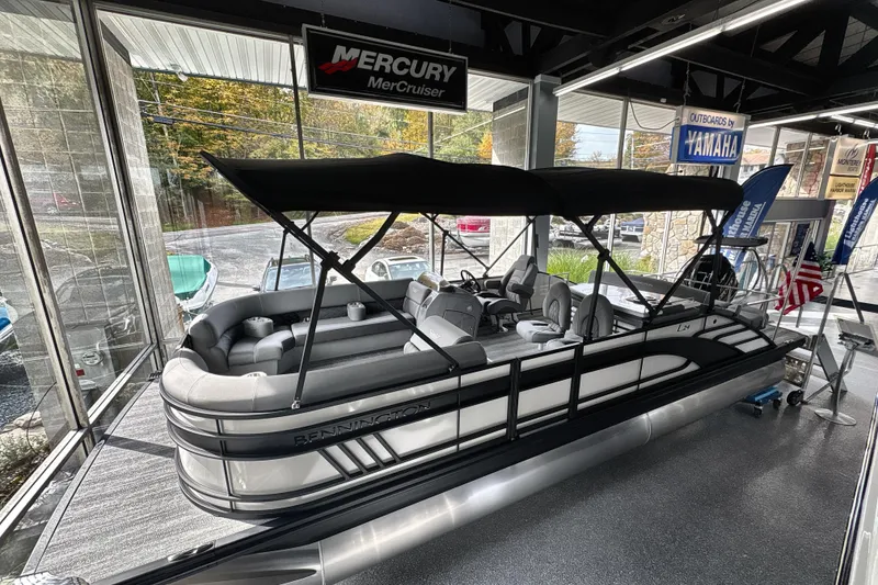 The Image of 2026 Bennington 24 LSB pontoon boat displayed indoors with canopy and seating. - 0