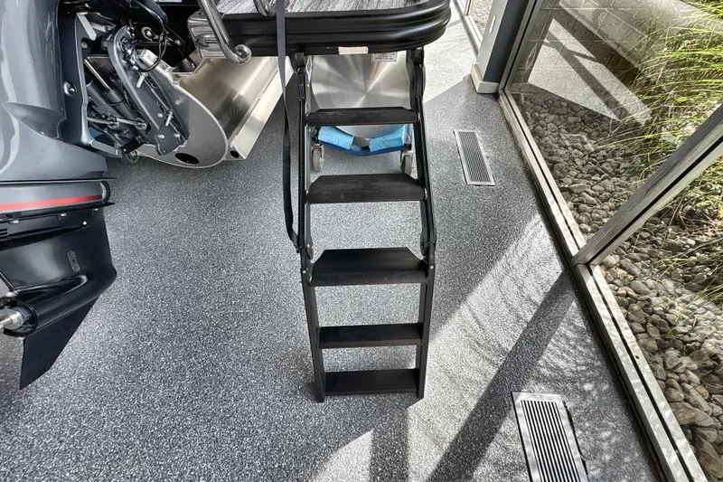 Slide: The Image of 2026 Bennington 24 LSB boat ladder and motor in showroom setting. - 20