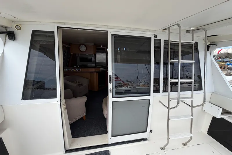 Slide: The Image of 1998 Bayliner 4788 Pilot House Motoryacht interior view with open sliding doors and ladder. - 10