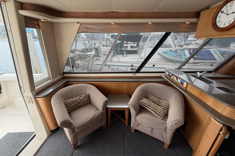 Slide: The Image of Interior of 1998 Bayliner 4788 Pilot House Motoryacht with cozy seating and marina view. - 12