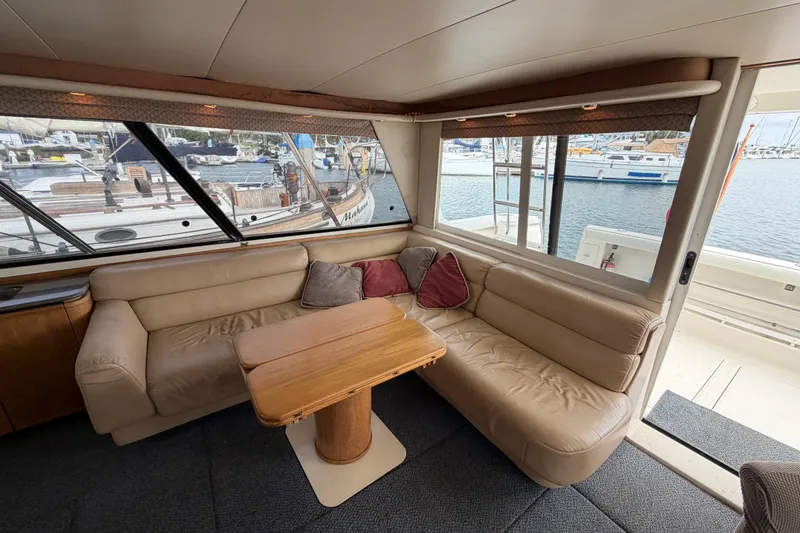 Slide: The Image of Luxurious interior of 1998 Bayliner 4788 Pilot House Motoryacht with leather seating and marina view. - 13