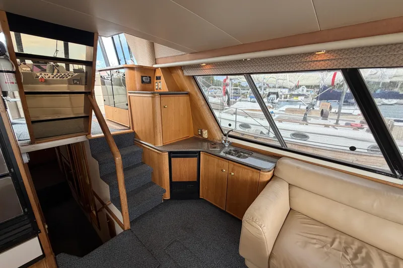 Slide: The Image of Interior of 1998 Bayliner 4788 Pilot House Motoryacht with stairs, kitchenette, and seating area. - 14