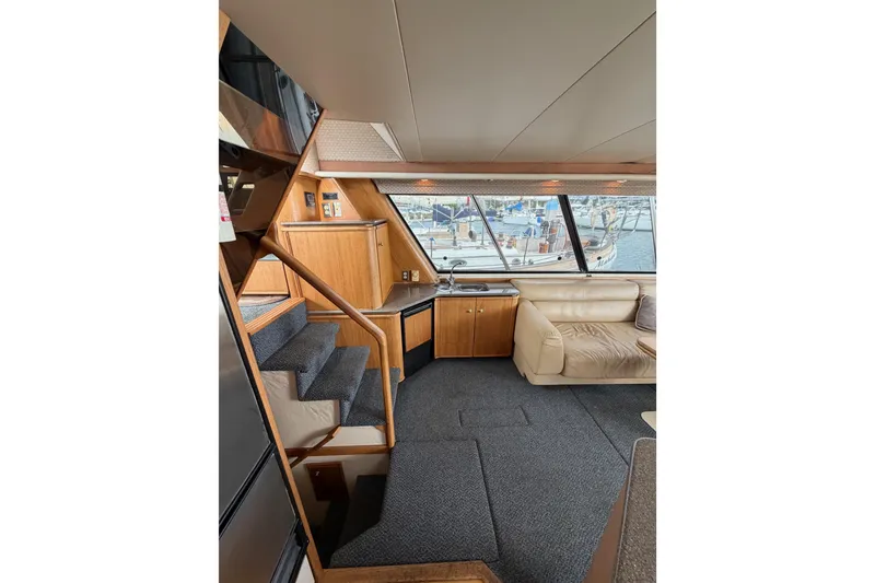 Slide: The Image of Interior of 1998 Bayliner 4788 Pilot House Motoryacht with stairs, seating, and large windows. - 20