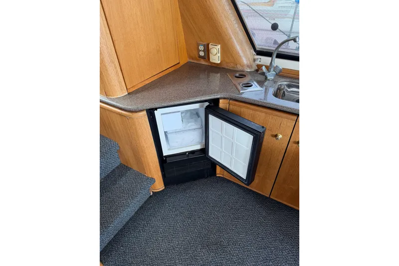 Slide: The Image of Interior of 1998 Bayliner 4788 yacht showing kitchenette with open mini fridge. - 22
