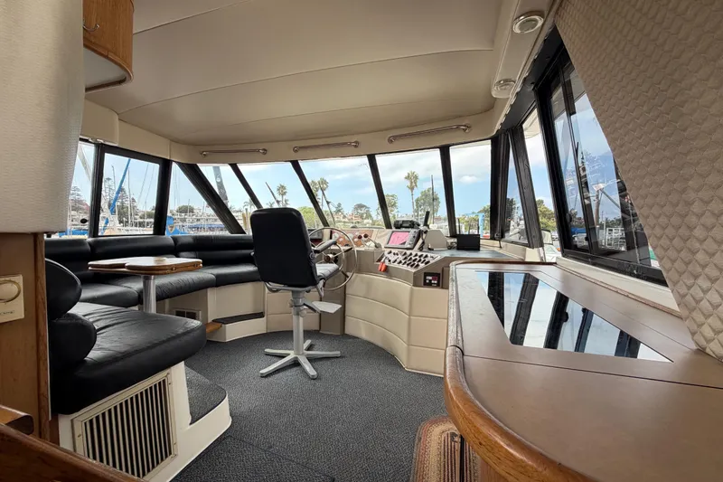 Slide: The Image of 1998 Bayliner 4788 Pilot House Motoryacht interior with helm, seating, and panoramic windows. - 25