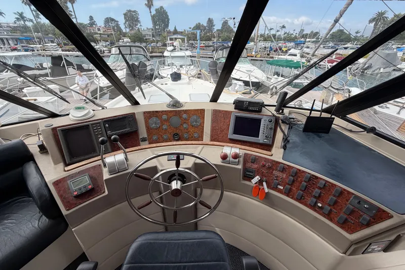 Slide: The Image of 1998 Bayliner 4788 Pilot House Motoryacht helm with navigation instruments and marina view. - 29
