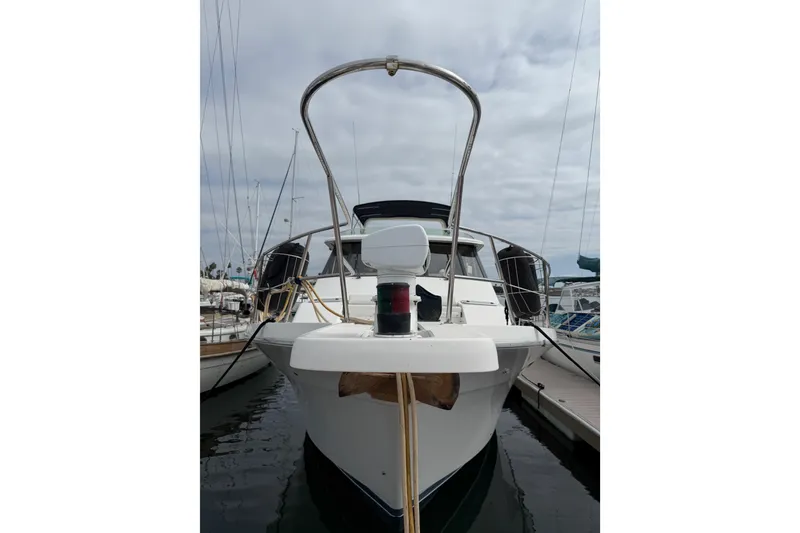 Slide: The Image of 1998 Bayliner 4788 Pilot House Motoryacht docked at marina, front view. - 3