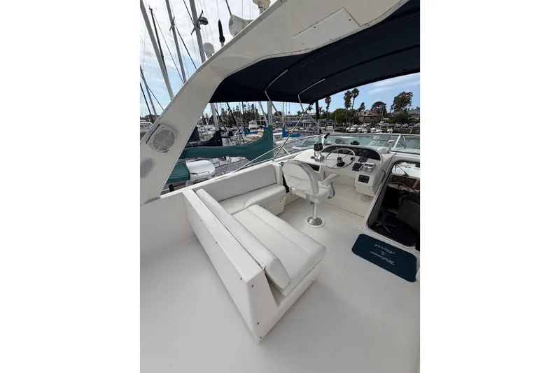 Slide: The Image of 1998 Bayliner 4788 Pilot House Motoryacht cockpit with seating and helm, docked at marina. - 44