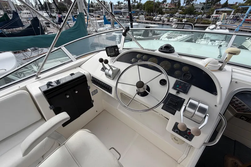 Slide: The Image of 1998 Bayliner 4788 Pilot House Motoryacht helm with steering wheel and controls at marina. - 45