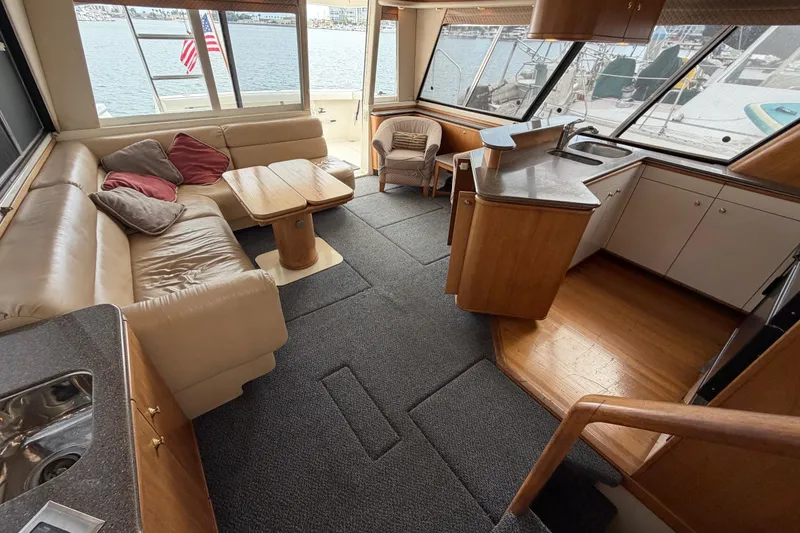 Slide: The Image of Luxurious interior of a 1998 Bayliner 4788 Pilot House Motoryacht with spacious seating and kitchen area. - 48