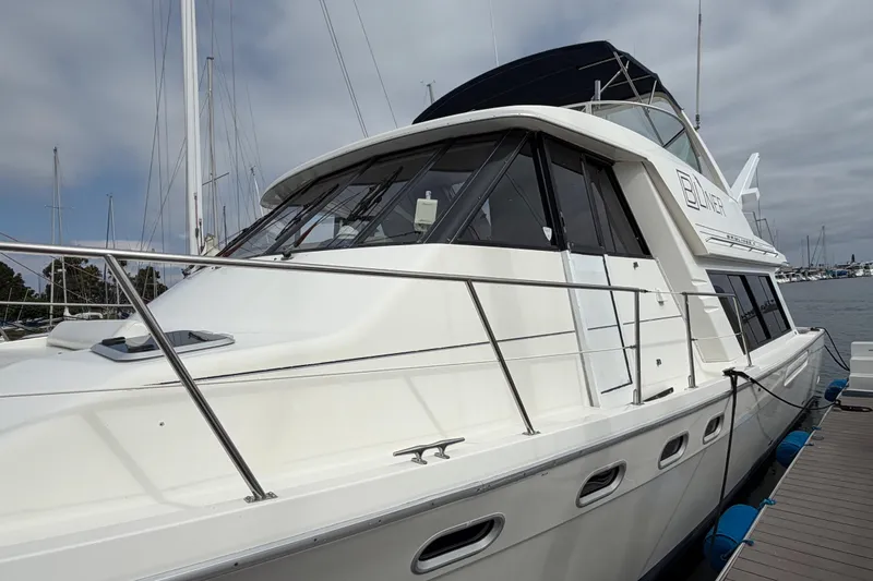 Slide: The Image of 1998 Bayliner 4788 Pilot House Motoryacht docked at marina, side view. - 5
