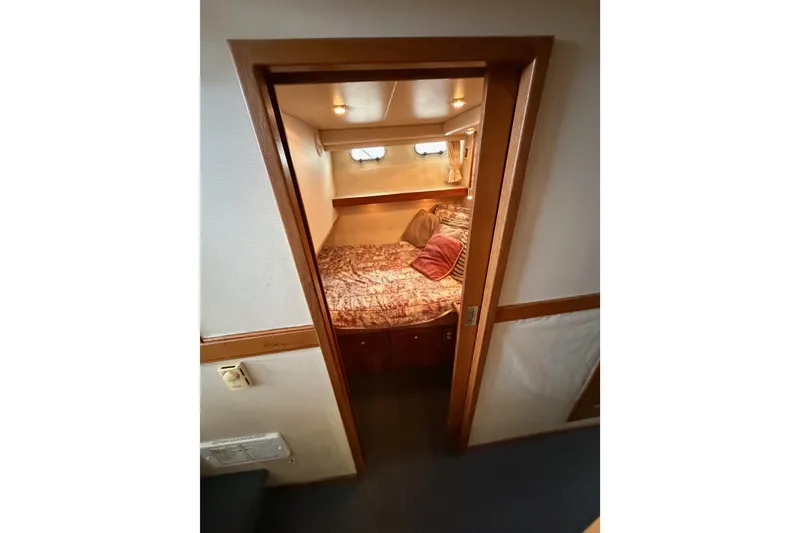 Slide: The Image of Cozy bedroom in 1998 Bayliner 4788 Pilot House Motoryacht with wood trim and soft lighting. - 53