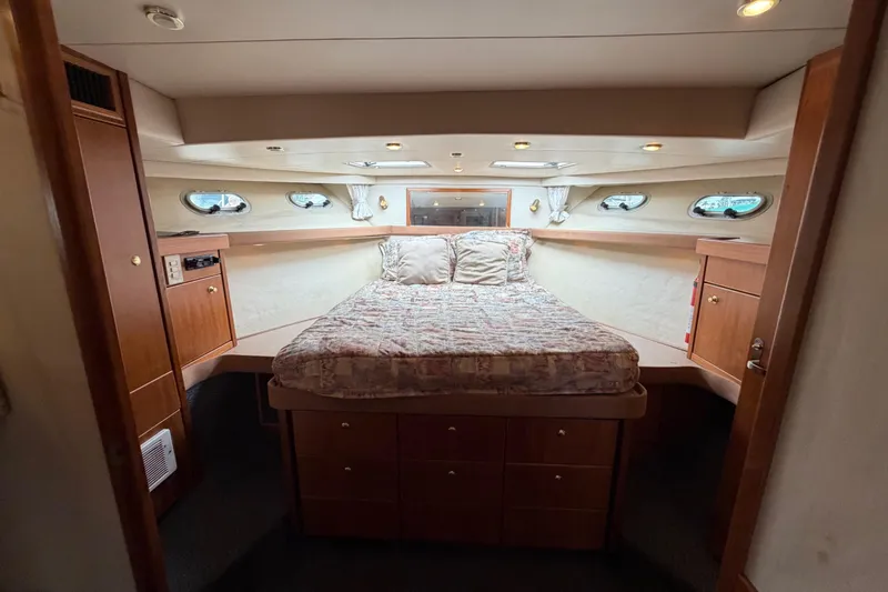 Slide: The Image of Luxurious bedroom interior of 1998 Bayliner 4788 Pilot House Motoryacht with cozy bed and wood cabinetry. - 57