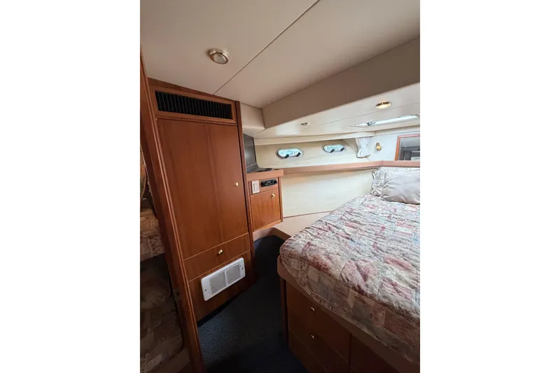 Slide: The Image of Interior of 1998 Bayliner 4788 Pilot House Motoryacht with cozy bedroom and wooden cabinetry. - 61