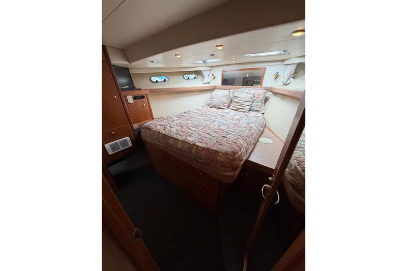 Slide: The Image of Cozy bedroom in 1998 Bayliner 4788 Pilot House Motoryacht with wood accents and porthole windows. - 66