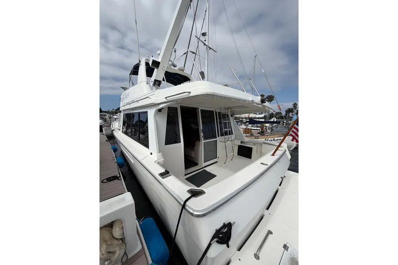 Slide: The Image of 1998 Bayliner 4788 Pilot House Motoryacht docked at marina, rear view. - 7