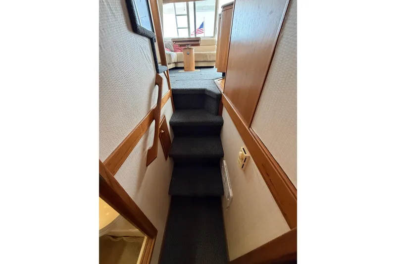 Slide: The Image of Interior stairs of 1998 Bayliner 4788 Pilot House Motoryacht, leading to a cozy seating area. - 70
