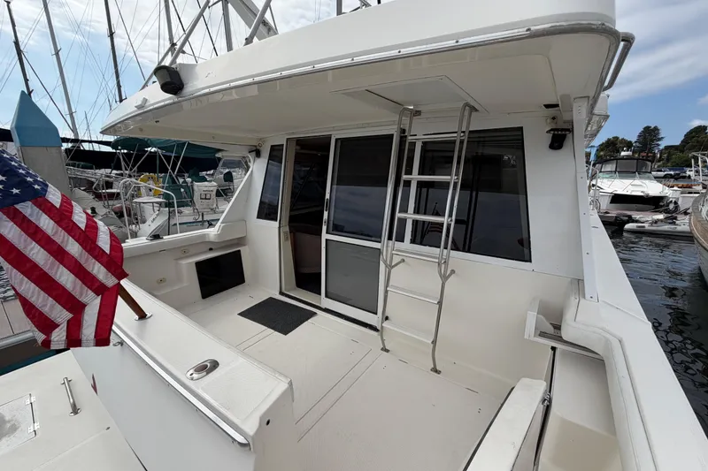 Slide: The Image of 1998 Bayliner 4788 Pilot House Motoryacht with American flag, docked at marina. - 9