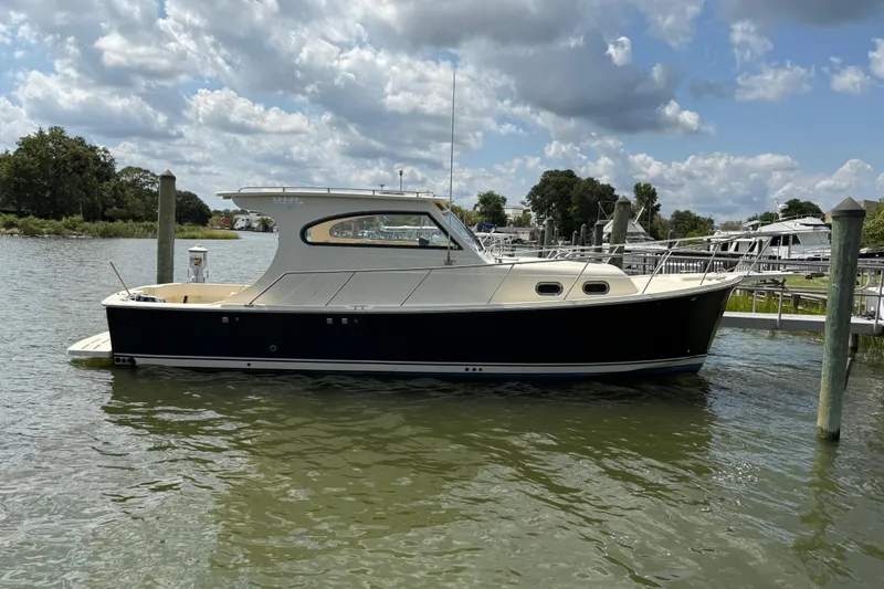 The Image of 2007 Mainship Pilot 30 Sedan docked on a sunny day with cloudy sky. - 0