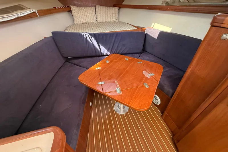 Slide: The Image of 2007 Mainship Pilot 30 Sedan interior with cozy seating and wooden table. - 10