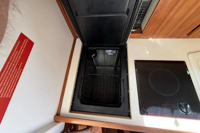Slide: The Image of 2007 Mainship Pilot 30 Sedan galley with stove and storage compartment. - 12