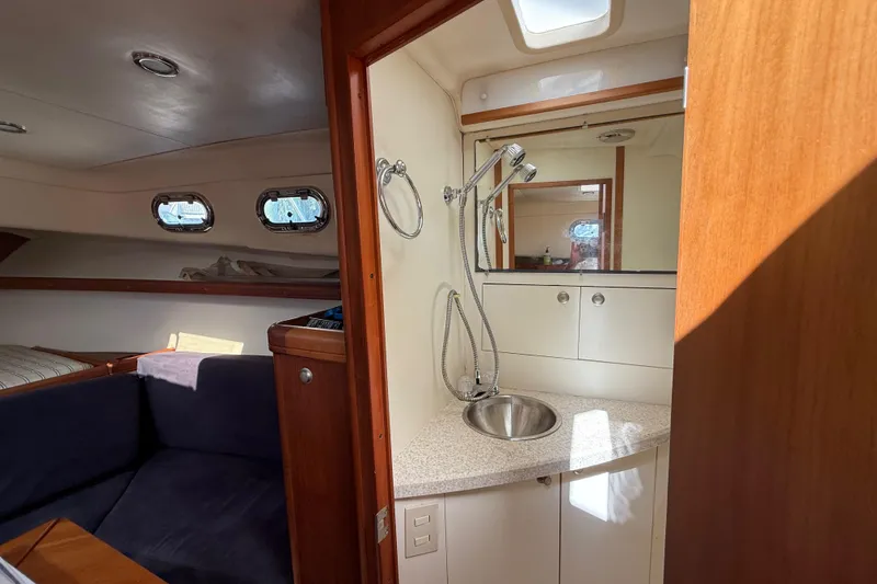 Slide: The Image of 2007 Mainship Pilot 30 Sedan interior with cozy cabin and compact bathroom. - 17