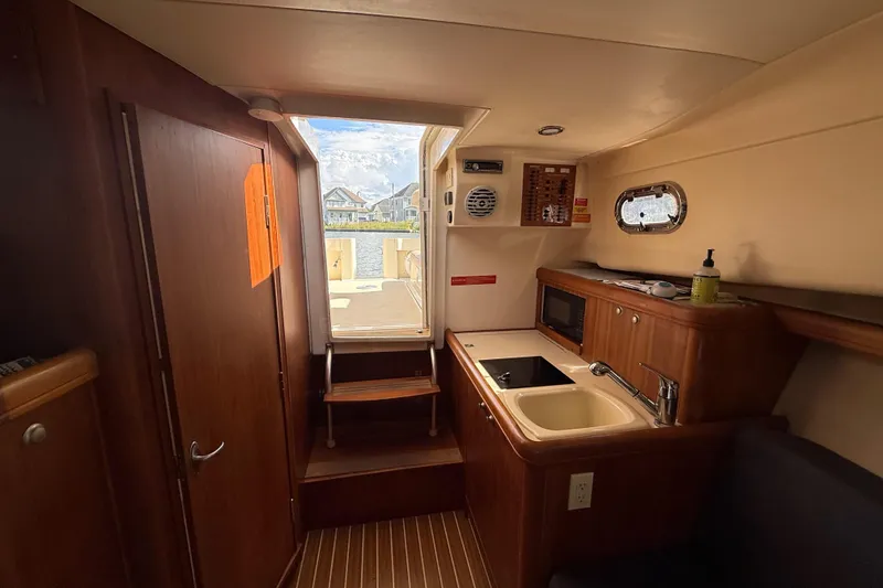 Slide: The Image of 2007 Mainship Pilot 30 Sedan interior with kitchenette, sink, and window view. - 20