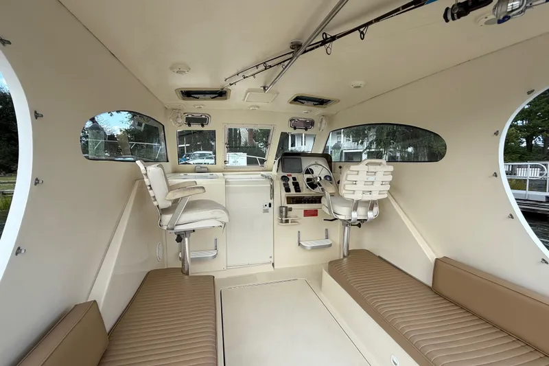 Slide: The Image of 2007 Mainship Pilot 30 Sedan interior with helm, seating, and windows. - 5
