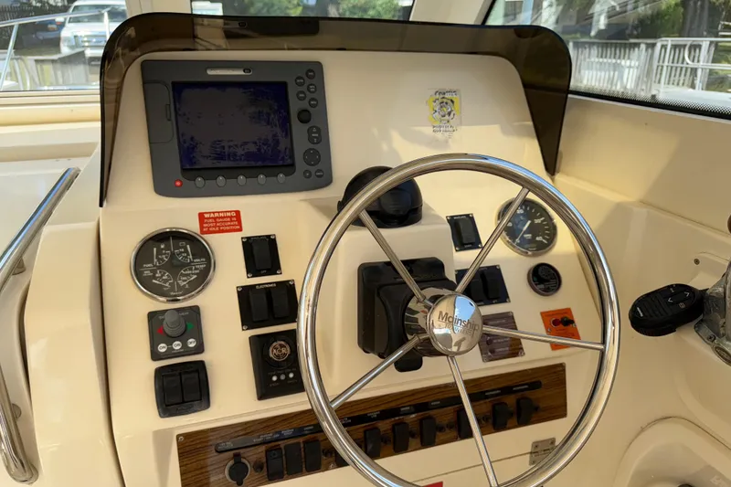 Slide: The Image of 2007 Mainship Pilot 30 Sedan helm with steering wheel and navigation controls. - 7