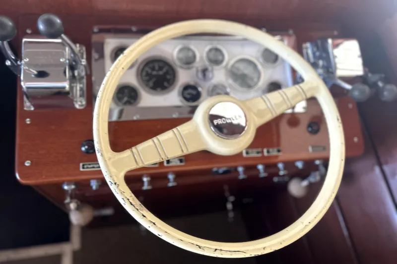 Slide: The Image of 1962 Prowler Forest Johnson boat dashboard with vintage steering wheel and controls. - 14