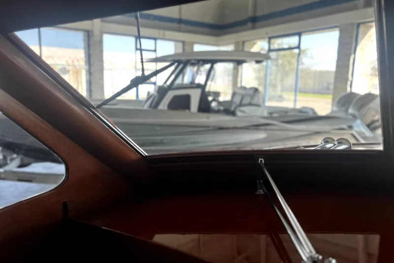 Slide: The Image of Interior view of a 1962 Prowler Forest Johnson boat, showcasing wooden details and marina background. - 19