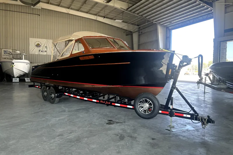 Slide: The Image of 1962 Prowler Forest Johnson boat on trailer in a spacious indoor facility. - 2