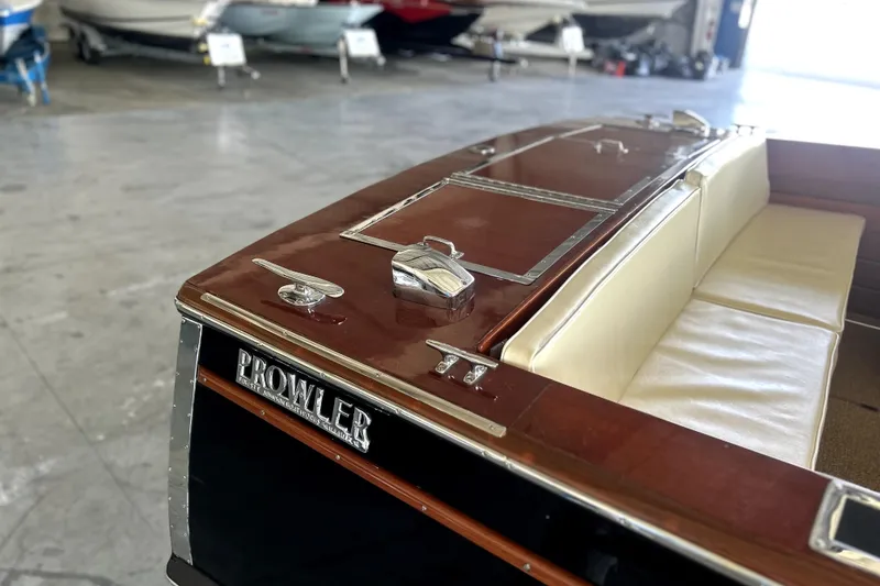 Slide: The Image of 1962 Prowler Forest Johnson boat with wooden deck and white seating in a showroom. - 36